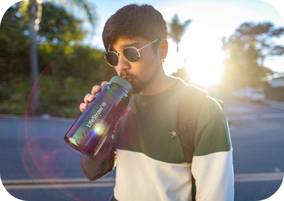 Mężczyzna pijący wodę z&nbsp;zielonej butelki LifeStraw Go 2.0 Terrace Green