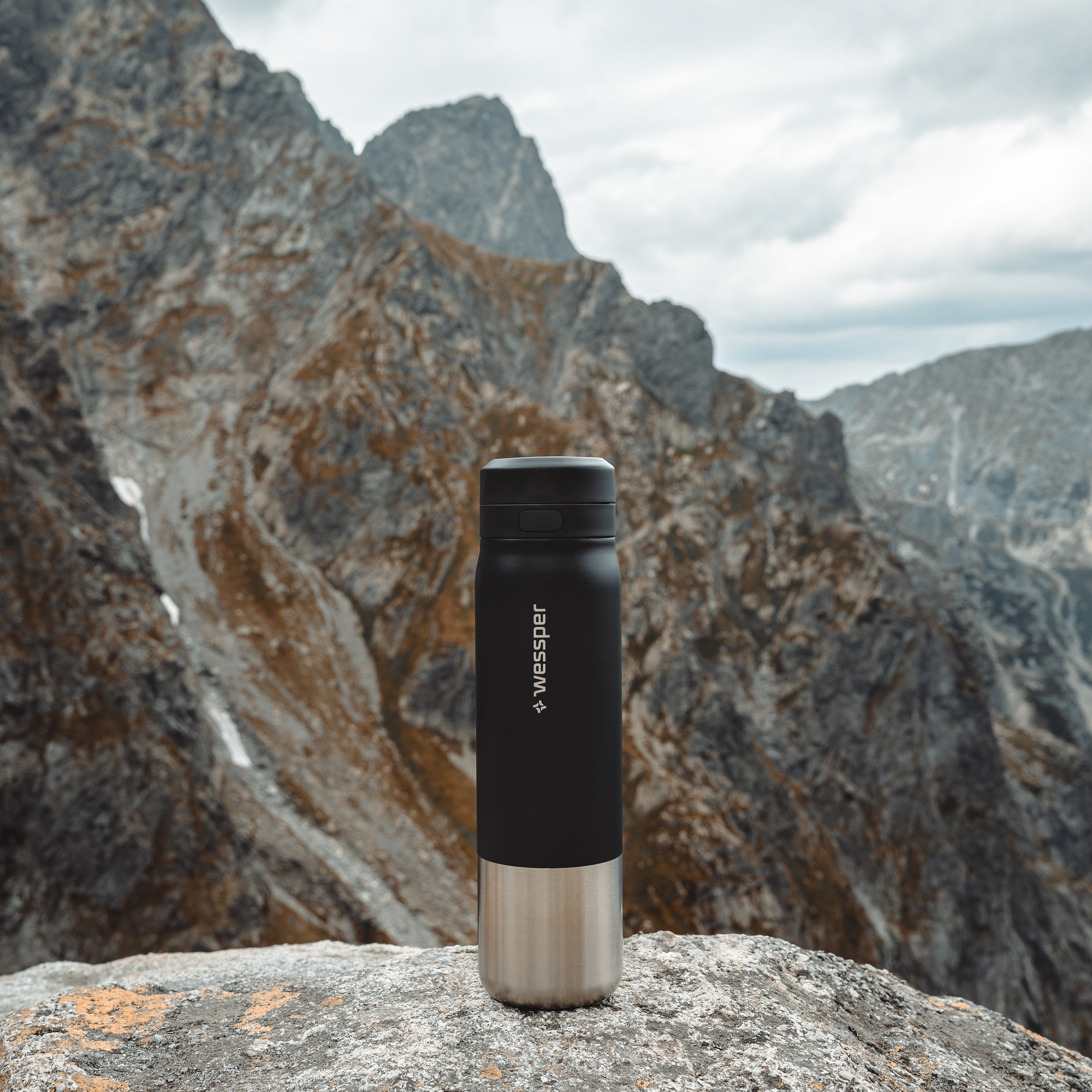 Butelka filtrująca Wessper czarna ze stali na tle górskiej panoramy