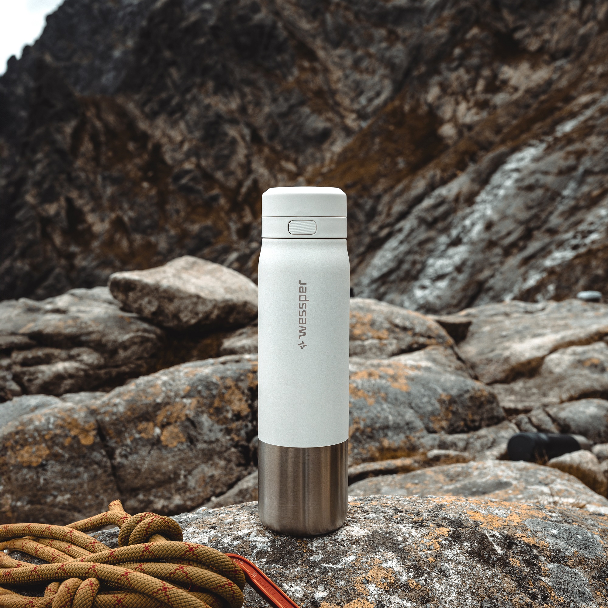 Biała butelka ze stali nierdzewnej na tle górskiej panoramy