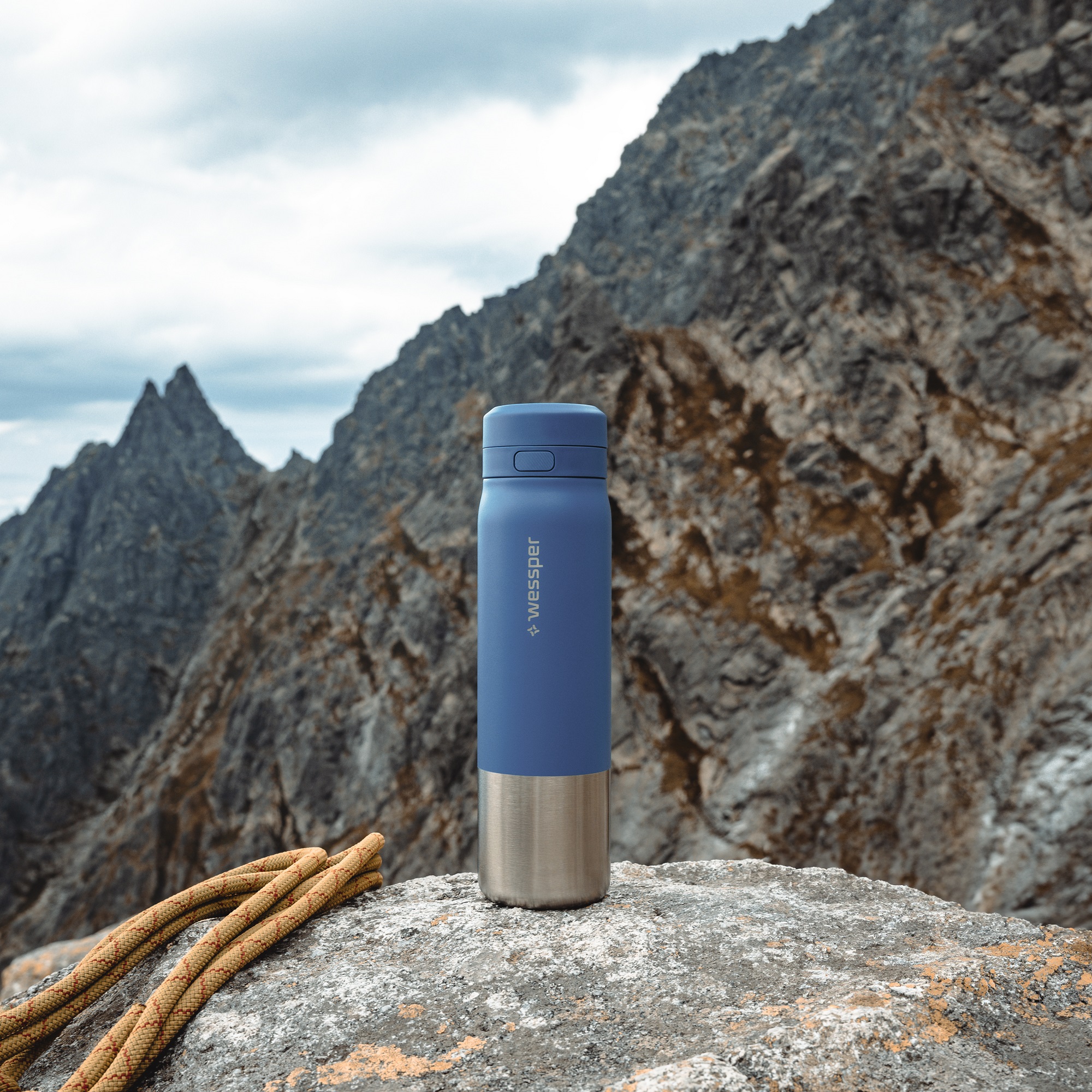 Butelka ze stali nierdzewnej i&nbsp;filtrem ustawiona na skale w&nbsp;wysokich górach