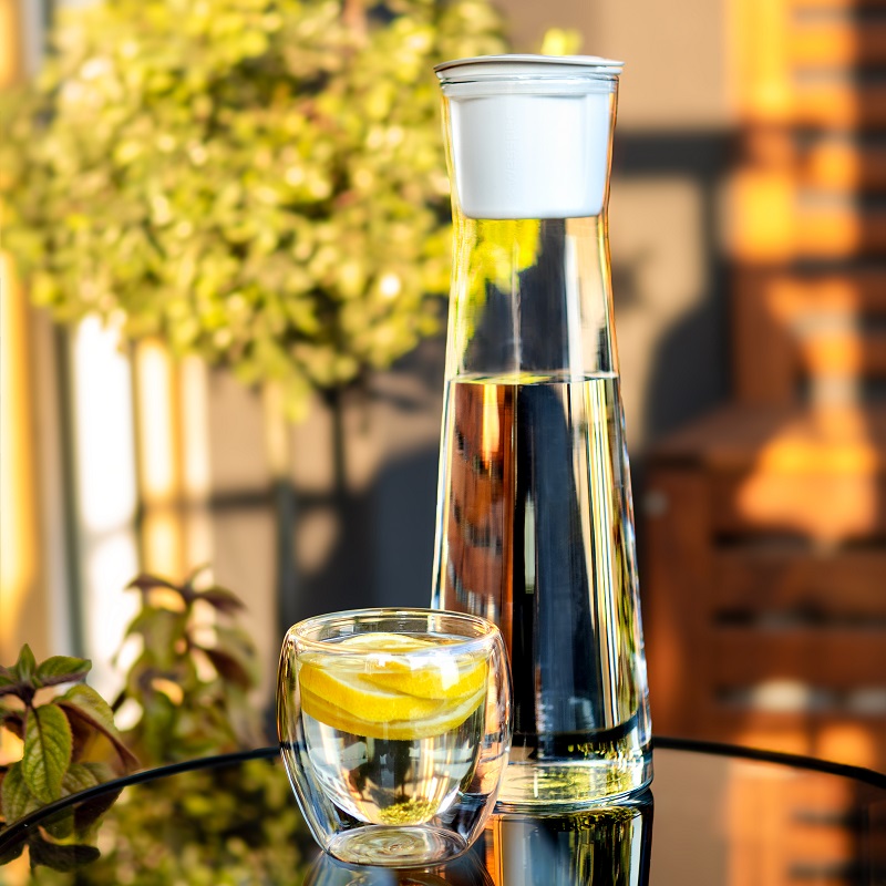 Biała karafka na szklanym stoliku na balkonowym stole - wessper K1